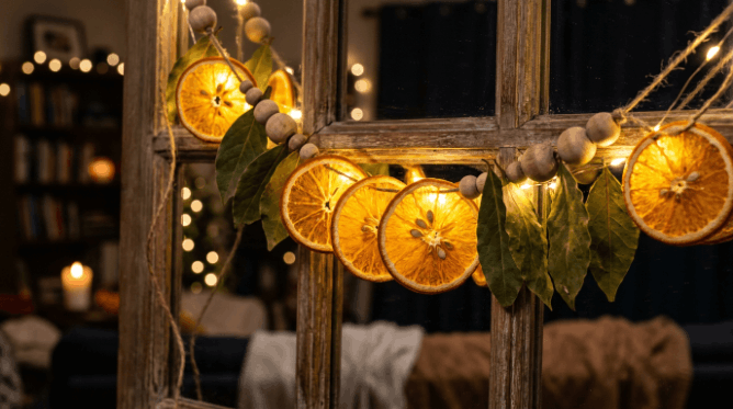 Dried orange slice garland with bay leaves lit by warm string lights