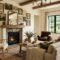 Updated modern farmhouse living room in 2026 featuring warm cream walls, mixed wood furniture, and vintage framed art.